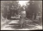 Mujer de pie en un camino de palmeras