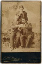 Retrato de tres hombres leyendo una hoja.