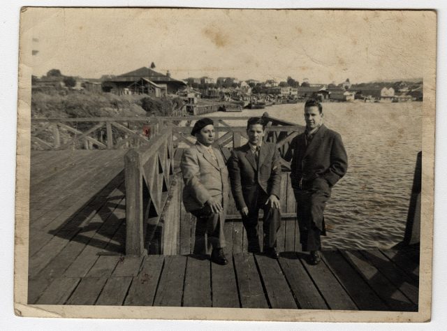 Tres hombres sobre un muelle