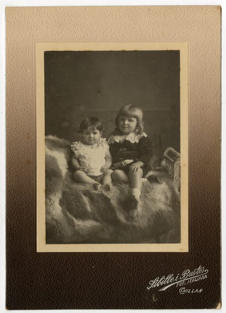 Retrato de dos niños sobre una cama