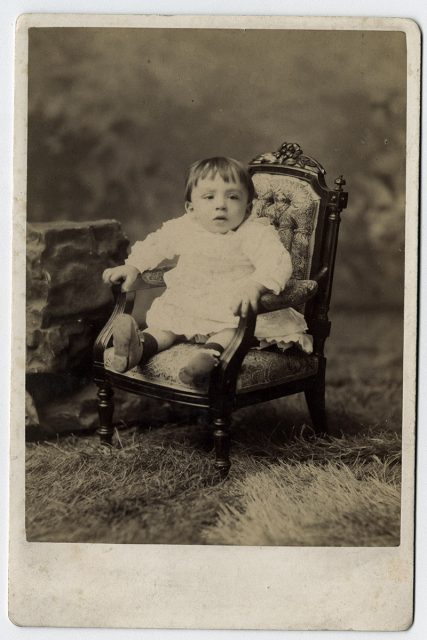Retrato de un niño pequeño sentado en un sillón