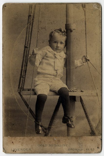 Niño sentado sobre una viga de bote