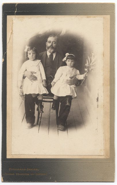 Retrato de un hombre con dos niñas sentadas sobre sus rodillas