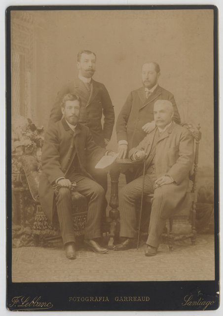 Retrato de cuatro hombres alrededor de una mesa