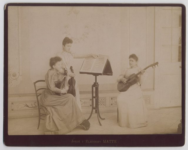 Retrato de tres mujeres tocando música en un salón