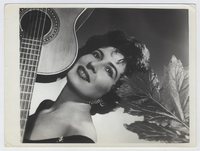 Mujer junto a una guitarra