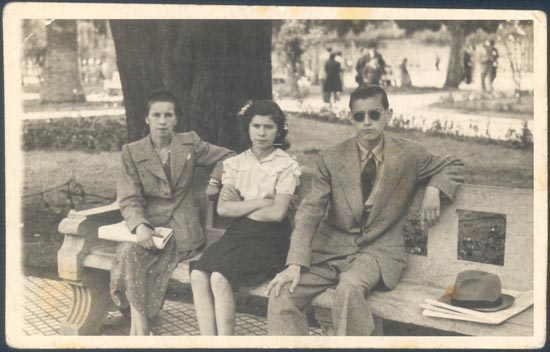Familia sentada en banco de una plaza