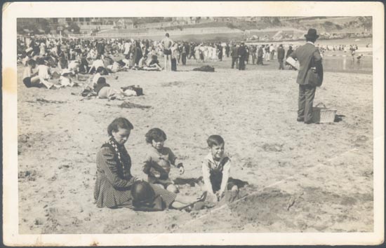 Madre con sus hijos jugando sobre la playa