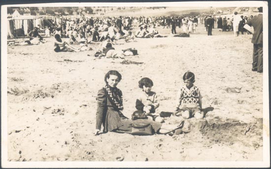 Madre con sus niños jugando sobre la playa