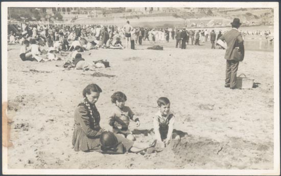 Madre con sus hijos jugando sobre la playa