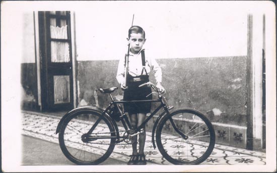 Juan Bley Monroy con una bicicleta y una escopeta.