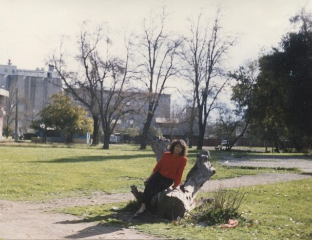 Mujer en sentada sobre la raíz de un árbol cortado en el Parque Koke